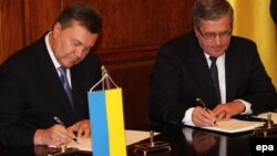 Віктор Янукович (ліворуч) і Броніслав Коморовський підписують план польсько-української співпраці на 2013-2015 роки, Краків, 7 вересня 2013 року