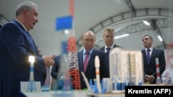 Руският президент Владимир Путин (в средата) слуша ръководителя на руската космическа агенция Роскосмос Дмитрий Рогозин (вляво), докато посещава космодрума "Восточний" през септември 2021 г.