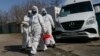 Workers wearing protective suits disinfect a public bus as a preventive measure against the coronavirus in the separatist-controlled city of Donetsk. 