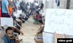 Prisoners who are sentenced to death at Iran's Ghezel Hesar hold up protest signs on July 16 as part of their hunger strike.