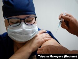 Врач получает инъекцию российской вакцины Спутник V