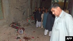 Pakistani residents gather on a street after a suicide blast targeting a Shi'ite procession in the southern Pakistani city of Jacobabad on October 23.