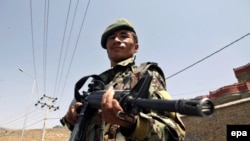A member of the Afghan security forces stands guard on a roadside as security is increased following reports of the death of Mullah Omar, the leader of the Afghan Taliban, in Kabul, on July 29.