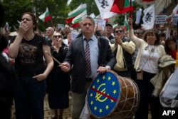Людина б’є в барабан з перекресленим логотипом євро під час демонстрації проти вступу Болгарії до єврозони в Софії 31 травня 2025 року