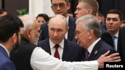 Нарендра Моди (чап), сарвазири Ҳиндустон, Владимир Путин (байн), президенти Русия ва Шавкат Мирзиёев (рост), раисҷумҳури Узбекистон
