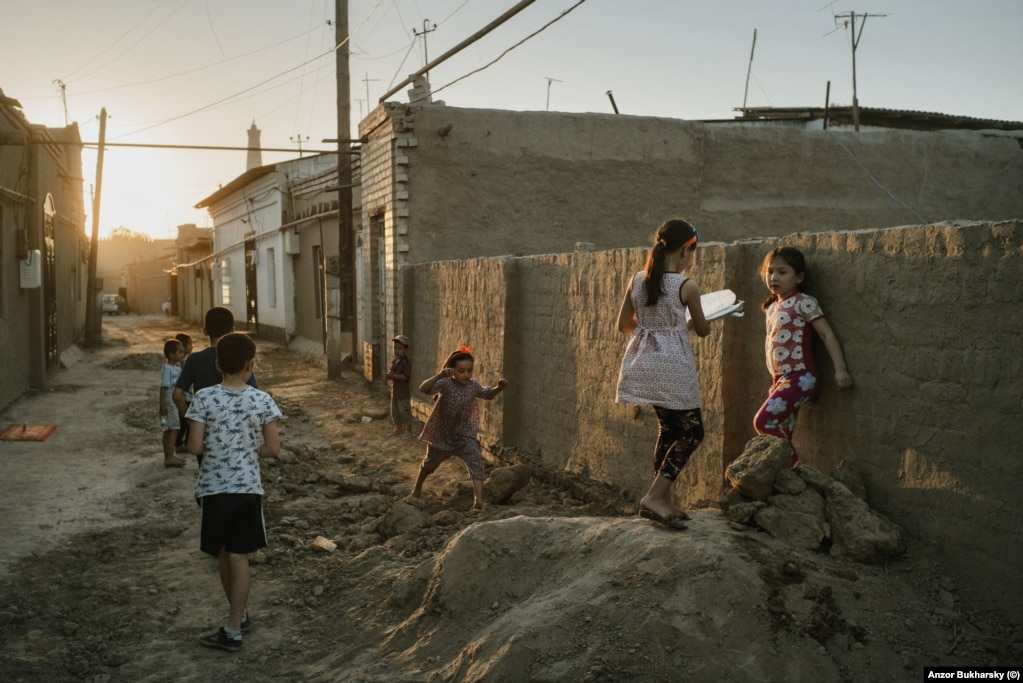 Local children play on one of the streets of old Khiva on a warm evening.