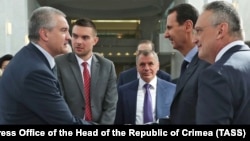Сергей Аксенов (слева) и Башар Асад (справа на втором плане) во время встречи в Сирии