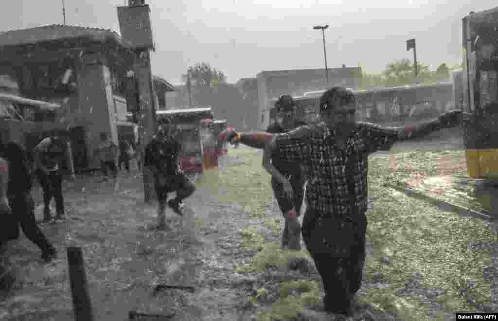 Pedestrians attempt to cross a street during a heavy downpour of rain and hail near Istanbul. (AFP/Bulent Kilic)