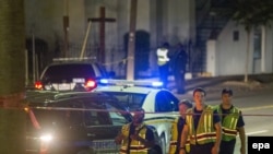 Полицейские перед церковью в Чарлстоне, где неизвестный открыл огонь, 17 июня 2015 года