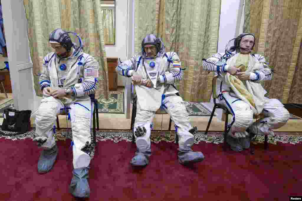 U.S. astronaut Christopher Cassidy (left) and Russian cosmonauts Alexander Misurkin (right) and Pavel Vinogradov put on space suits before taking part in a training exercise on a simulator at the cosmonaut training center at Star City outside Moscow. The three-man crew is due to blast off to the International Space Station on March 28. (Reuters/Sergei Remezov)