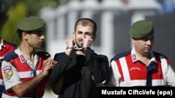 An unidentified soldier accused of attempting to assassinate Turkish President Tayyip Erdogan during last year's failed July 15 coup, is escorted by police as he arrives at the final hearing of his trial in Mugla on October 4.