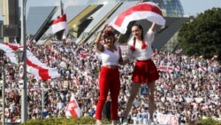 BELARUS – Two women wave an old Belarusian national flag during an opposition rally in the center of Minsk, August 16, 2020