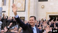 President Bashar al-Assad waves to supporters after he addressed parliament in Damascus on March 30.