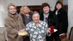 Представники керченської влади вручили жінці похилого віку, яка пережила блокаду Ленінграда, батон і медаль