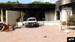 Сгоревшая постройка и машина консульства США в Бенгази.12 сентября 2012 года.