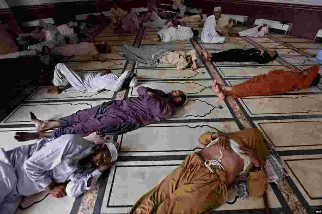 Muslim men rest in the heat at a mosque in Peshawar.