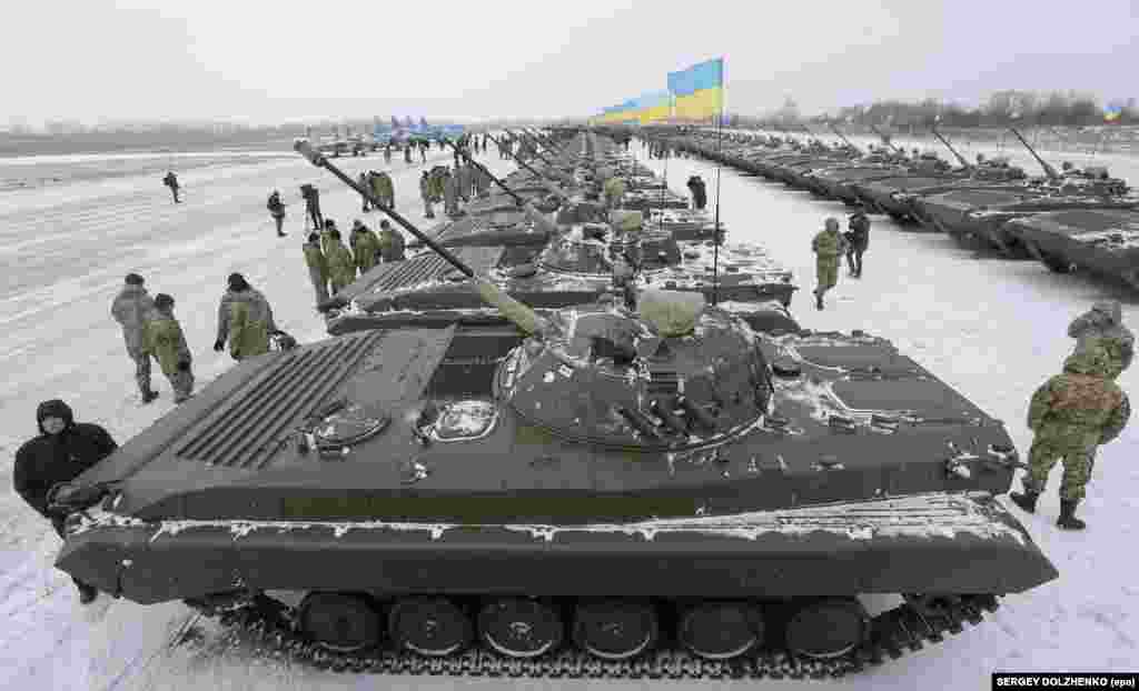 Ukrainian servicemen stand near armored personal carriers at a military base near Zhytomir, about 140 kilometers west of the capital, Kyiv. Ukrainian President Petro Poroshenko handed over to the Ukrainian Army more than 100 pieces of military equipment, aircraft, and weapons. (epa/Sergei Dolzhenko)