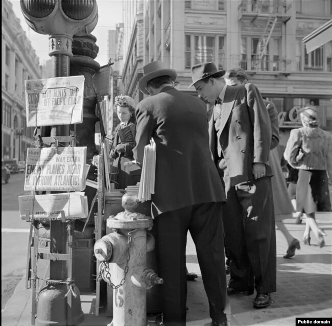 Уличная сценка в США в 1940-е: заголовки газет сообщают о японских авиарейдах