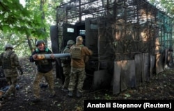 Військові 15 БрОП Нацгвардії України «Кара-Даг» розвантажують боєприпаси для реактивної пускової установки «Град-П» («Партизан») на позиції поблизу прифронтового Добропілля на Донеччині, Україна, 25 вересня 2026 року