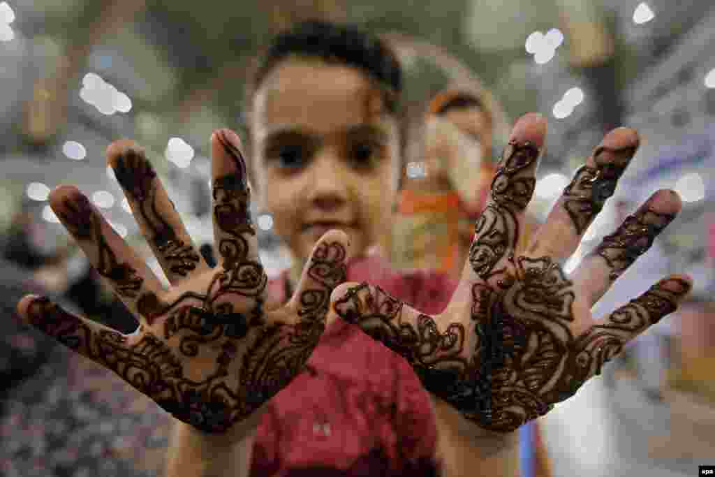 A young girl in Peshawar, Pakistan, applies a henna design on her hands ahead of the Eid al-Fitr festival marking the end of Ramadan. (epa/Bilawal Arbab)
