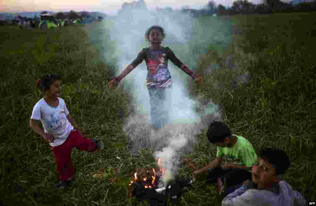 Children gather around a campfire in a makeshift camp at the Greek-Macedonian border near the Greek village of Idomeni, where over 11,000 refugees and migrants are currently stranded by the Balkan border blockade. (AFP/Bulent Kilic)