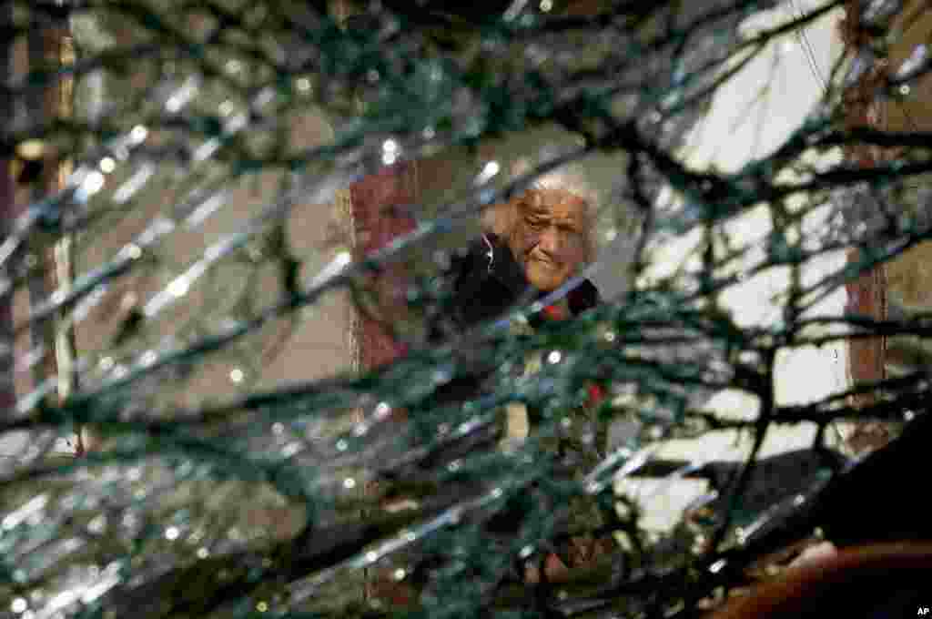 A photo taken through the broken windshield of a car damaged by shelling shows an 88-year-old woman standing near her house in Stepanakert, the main city of the breakaway region of Nagorno-Karabakh. (AP)