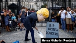 Downing Streetiň garşysynda Boris Jonson maskasyny geýen protestçi. London.