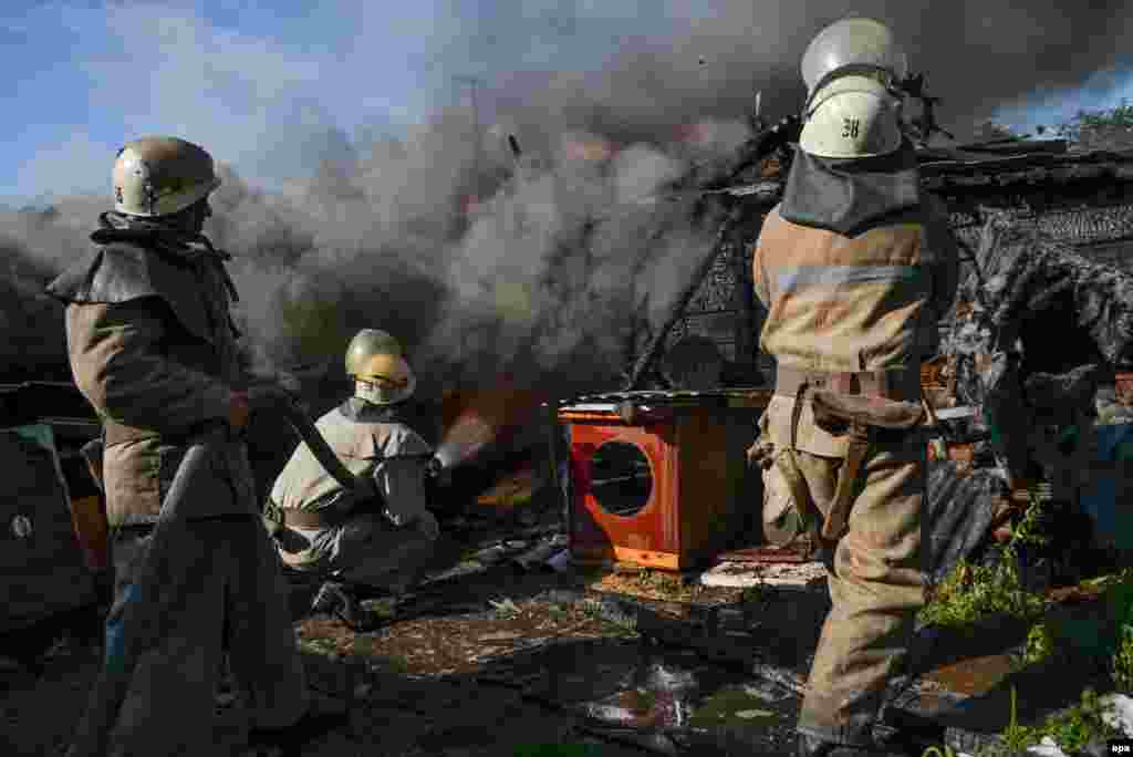 Firefighters exstinguish a smoldering house, which was destroyed by shelling in Slovyansk in Ukraine&#39;s Donetsk region on June 30. (epa)