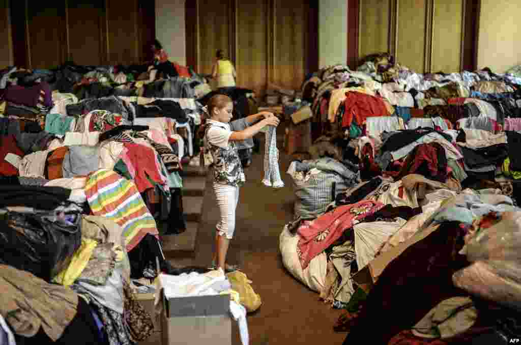 Rusiyayönlü separatçıların ələ keçirdiyi binada qız qalaqlanmış paltarlara baxır&nbsp;