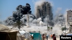 Palestinieni aleargă în momentul în care un turn de 15 etaje din Gaza City se prăbușește în urma loviturilor aeriene israeliene. 5 septembrie 2025. 