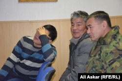 Подсудимый Каиргали Оразжанов (слева) прячет свое лицо. Актобе, 21 декабря 2016 года.