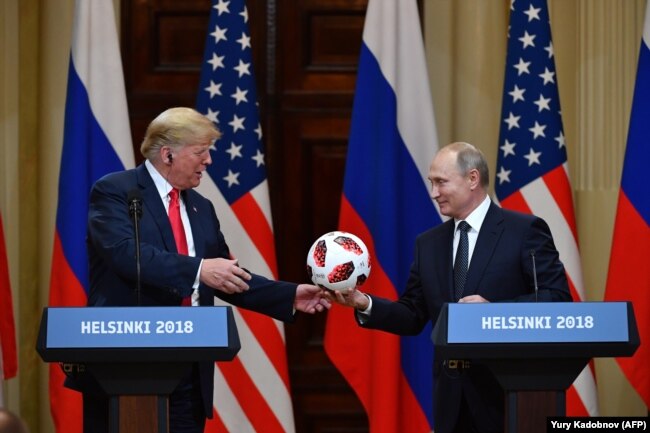 Ruski predsednik Vladimir Putin (desno) daje loptu sa Svetskog fudbalskog prvenstva američkom predsedniku Donaldu Trampu, tokom zajediničke konferencije za novnare posle sastanka u Helsinkiju, jul 2018.