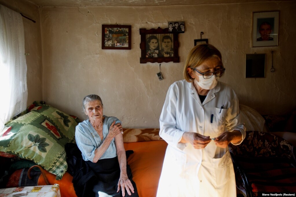 Një punonjëse mjekësore përgatit një injeksion, teksa një fshatare e moshuar pret.  Deri më 12 maj, pak më shumë se 5 për qind e popullatës së Malit të Zi është vaksinuar plotësisht.