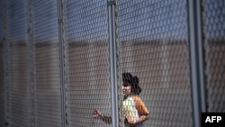 O fată din Siria în spatele gardului care înconjoară adăpostul pentru imigranți clandestini de la Liubimeț, Bulgaria