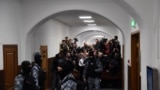 Russian law enforcement officers stand guard as journalists wait for suspects in the deadly attack on the Crocus City Hall to appear at the Basmanny District Court in Moscow on March 24, 2024.