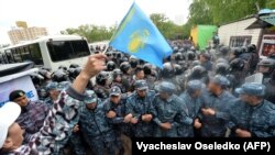 Женщина с флажком перед рядами полиции на мирной акции протеста в Нур-Султане. 9 июня 2019 года.