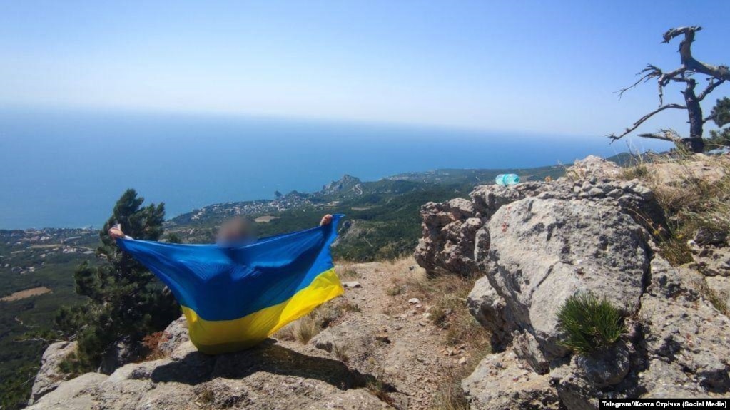 Підняття українського прапора на горі Шаан-Кая поблизу Алупки, Крим у 2025 році. Акція руху опору «Жовта стрічка», ілюстраційне фото