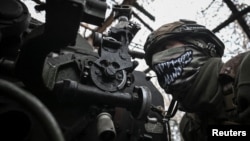 Артилерист 152-ї ОЄБр ЗСУ готується відкрити вогонь з гаубиці у бік російських військ поблизу прифронтового міста Покровськ, Донецька область, 11 грудня 2025 року