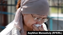Алтын Кошерова, мать раненного во время Жанаозенских событий подростка Рахата Кошерова, скончавшегося в больнице, стоит у здания суда в Актау, где проходят слушания по делу обвиняемых в «превышении полномочий» полицейских. 3 мая 2012 года.