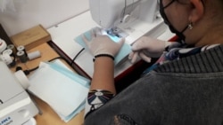 A volunteer sews a face mask together. The Echmiadzin team make the masks with a square of paper towel inside two layers of surgical fabric.