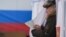RUSSIA -- A man walks out of a voting booth at a polling station during Russia's presidential election in Moscow on March 18, 2018. 