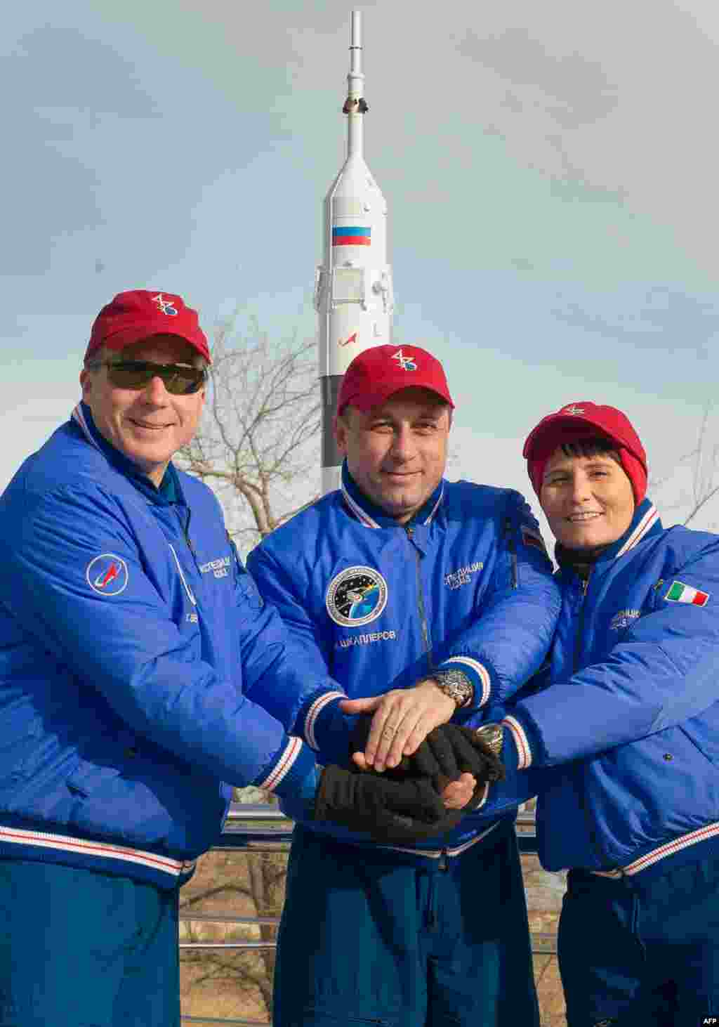 U.S. astronaut Terry Virts (left), Russian cosmonaut Anton Shkaplerov (center), and the European Space Agency's Italian astronaut Samantha Cristoforetti pose in front of the Soyuz TMA-15M space vehicle at its launch pad in Kazakhstan. The three are due to blast off for the International Space Station on November 23. (AFP)