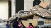 An Iraqi family sits outside its destroyed home in Diyala in March 2008