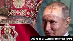 Crucea de pe mitra patriarhul Kirill aruncă o umbră pe fruntea lui Vladimir Putin în catedrala din Moscova, 28 aprilie, 2019