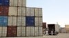 Iranian workers transfer goods from a cargo container to trucks at the port in the city of Chabahar.