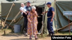 Internally displaced Ukrainians are assisted at a temporary camp for people from Svatovo, in Luhansk region, on August 12.