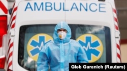 A medical worker wearing protective gear stands next to an ambulance outside a hospital for patients infected with the COVID-19 in the Ukrainian capital, Kyiv. (file photo)