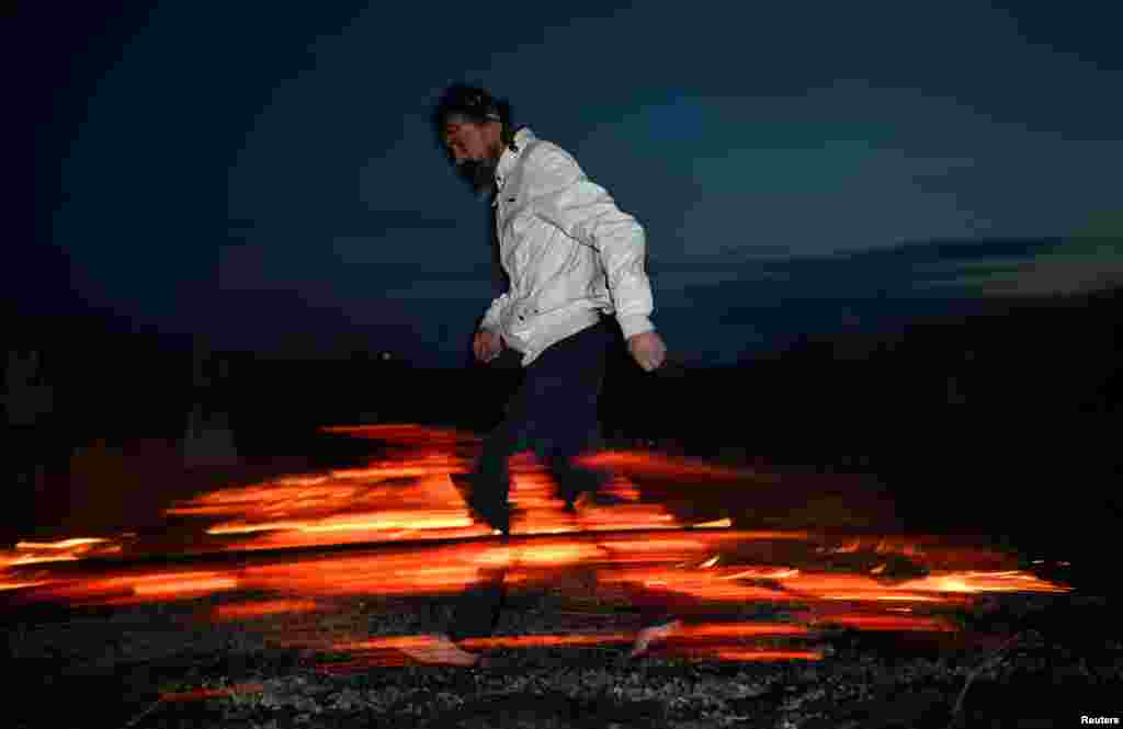 A man walks on hot coals during a celebration of the summer solstice at a festival in the village of Okunevo in Russia's Omsk region.