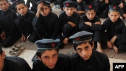 Boys attend a class at a school in a tribal agency in Pakistan's rugged northwest, where the goverment's battle with militants has destroyed the local econmy.