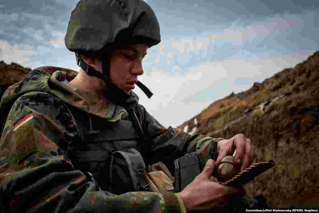 Боєць &laquo;Азова&raquo; перезаряджає зброю. Село Широкино в Донецькій області. 18 квітня 2015 року